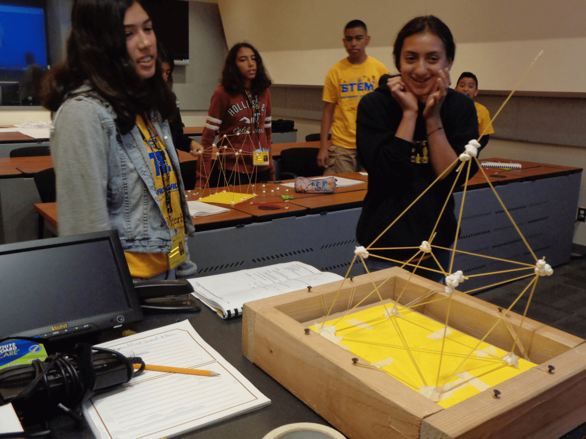 Students testing the stability of their spaghetti tower challenge
