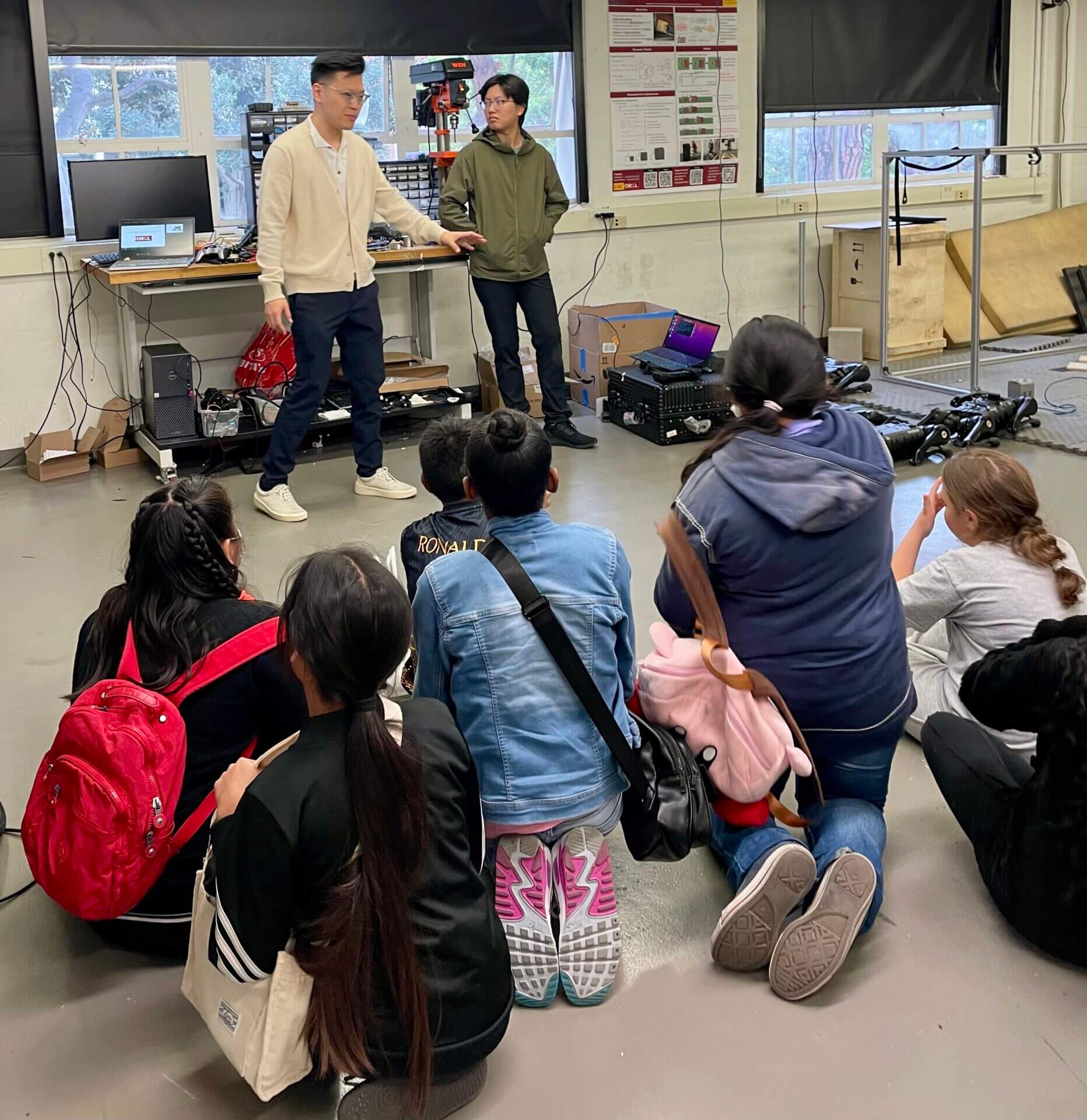 Children sitting and learning from the Professors